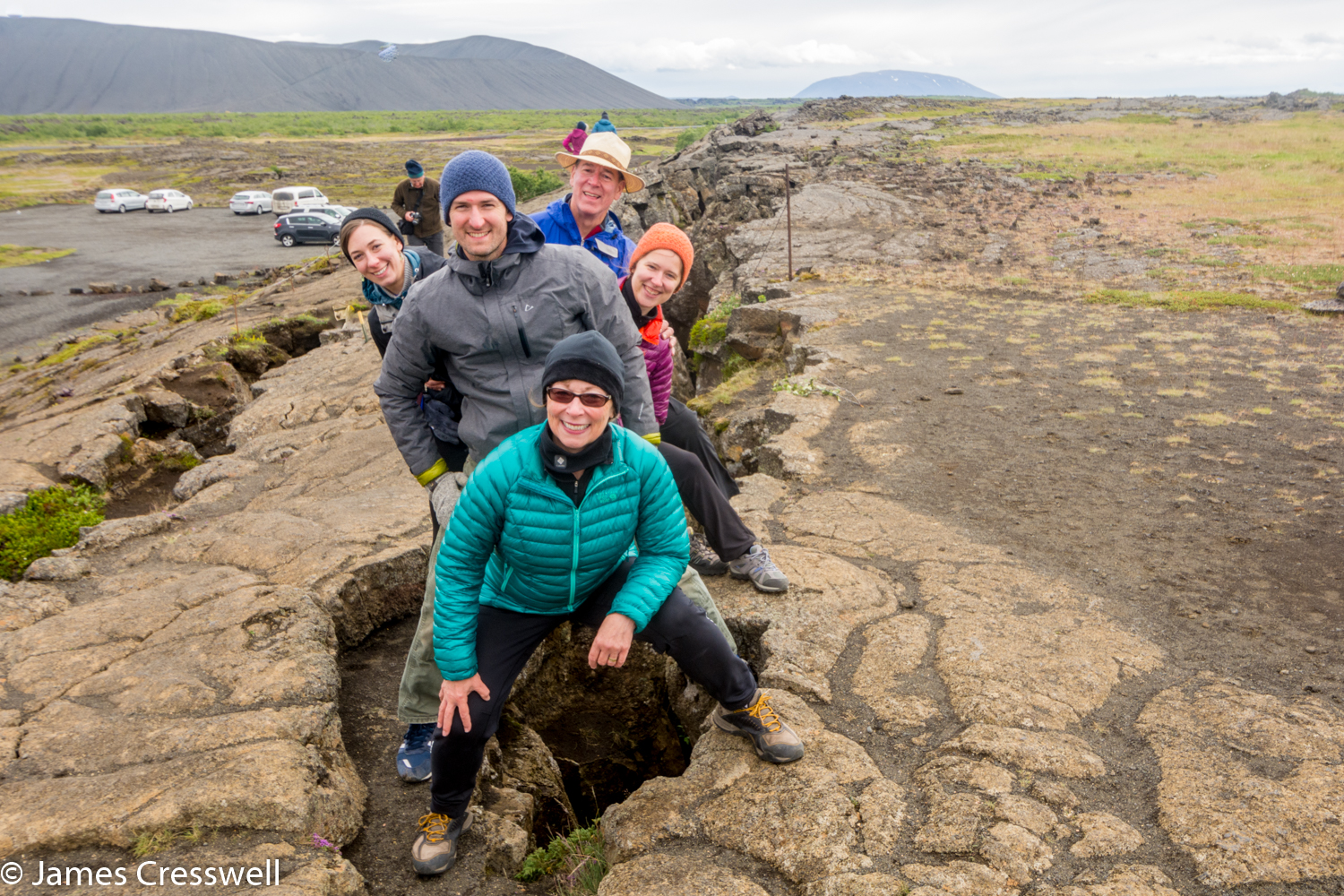 A photograph of people straddling a plate boundary, taken on a GeoWorld Travel Iceland volcano and geology trip, tour and holiday