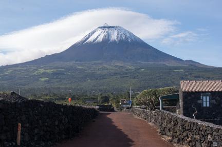 A photograph of a cone shaped volcano capped in snow. The volcano is Pico taken on GeoWorld Travel's geology of the Azores tour 