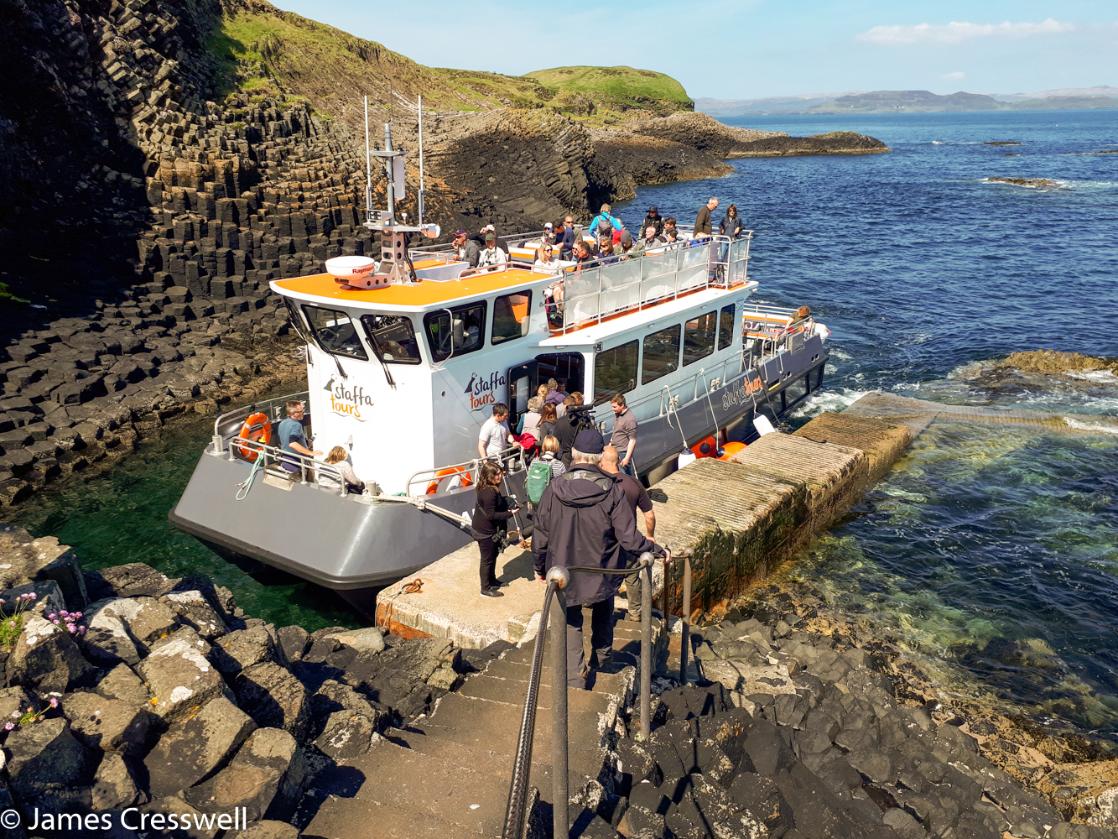 A photograph of boat docked at the Isle of Staffa taken on GeoWorld Travel's geology of Scotland tour