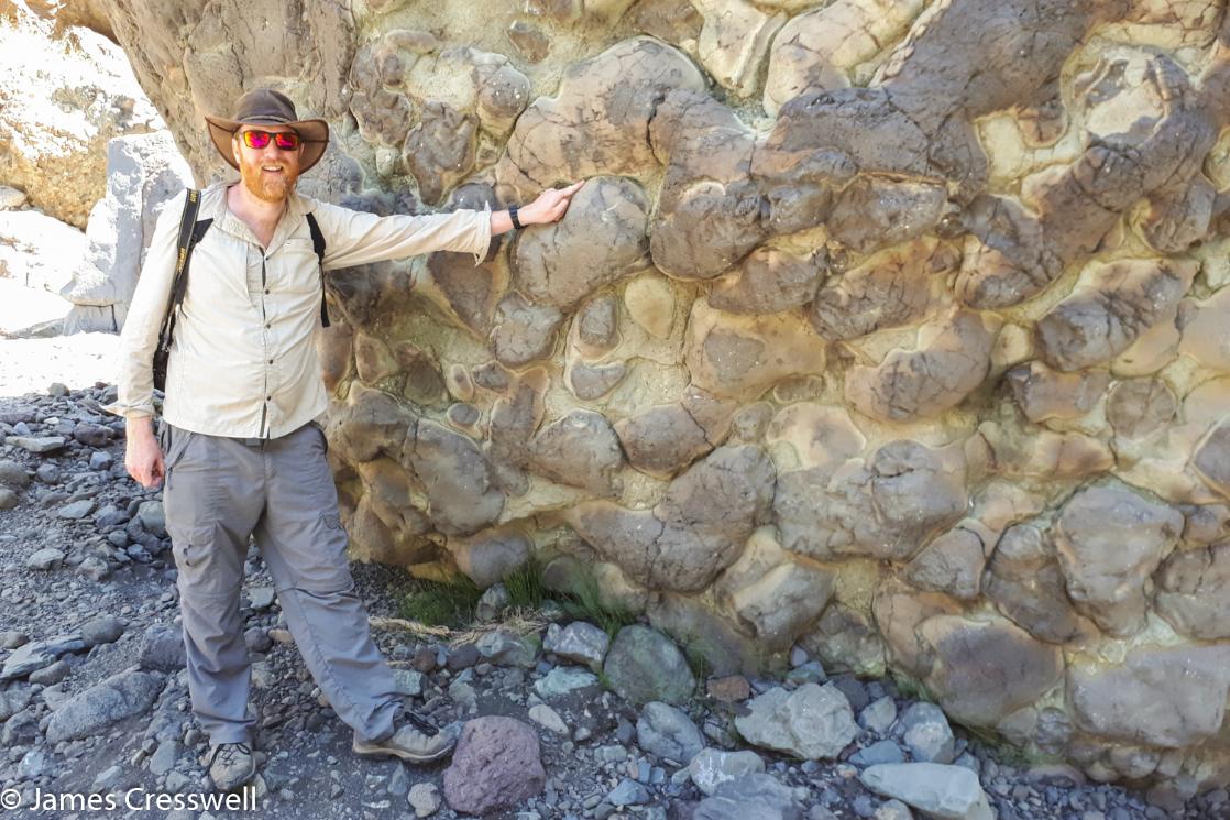 A photograph of James Cresswell pointing to pillow lavas on La Palma on a GeoWorld Travel Canary Islands geology and volcano tour, trip and holiday