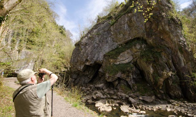 A man photographs a geological fold, the fold is Bwa Maen in the Fforest Fawr Geopark on a GeoWorld Travel day trip