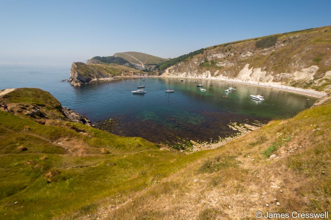 A photograph of a perfectly round bay, Lulworth Cove, taken on the GeoWorld Travel England and Wales geology trip, tour and holiday