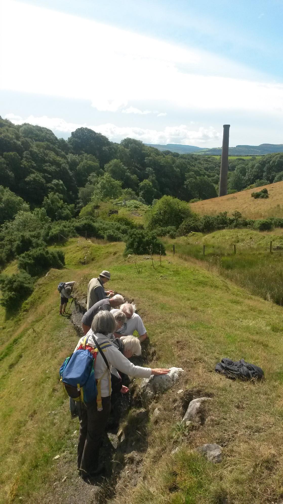 A photograph of a people examining coal in situ at Henllys Vale colliery, taken on a GeoWorld Travel Fforest Fawr Geopark geology day tour