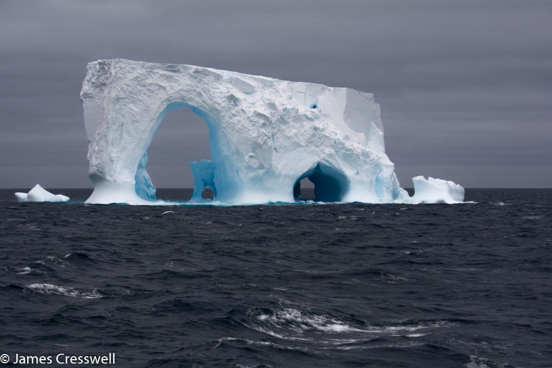 A photograph of a tabular iceberg with two arches, taken in the Ross Sea Antarctica, on a PolarWorld Travel placed cruise