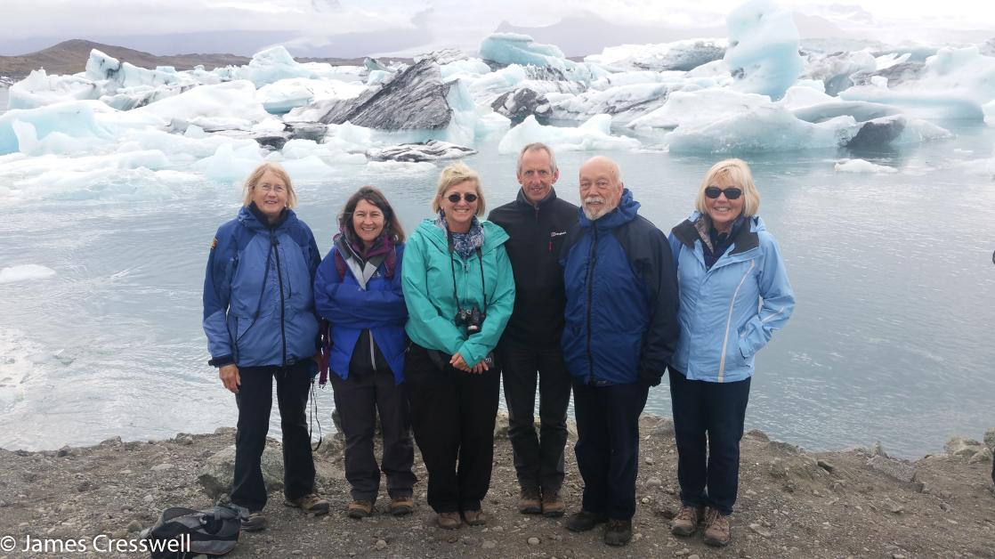 A photograph of five people standing in front of icebergs in Jokulsarlon Lagoon, taken on a GeoWorld Travel iceberg trip and geology holiday