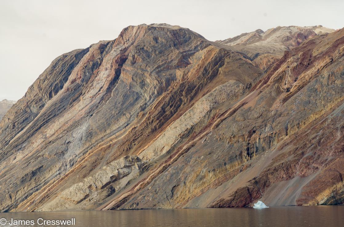 A photograph of Eleonore Bay Formation sedimentary rock layers in Antarctic Sound, northeast Greenland, taken on a PolarWorld Travel polar expedition cruise