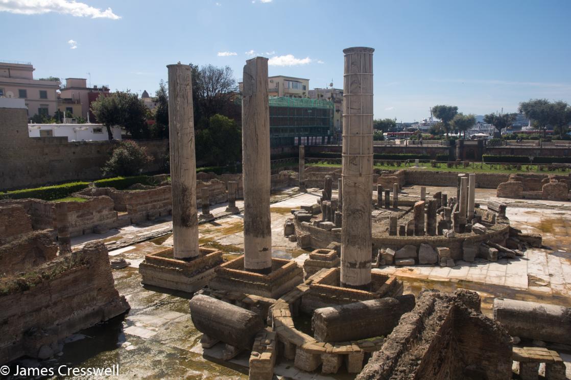 A photograph of three Roman pillars, the Temple of Serapsis in Italy, taken on a GeoWorld Travel History of Geology trip and tour