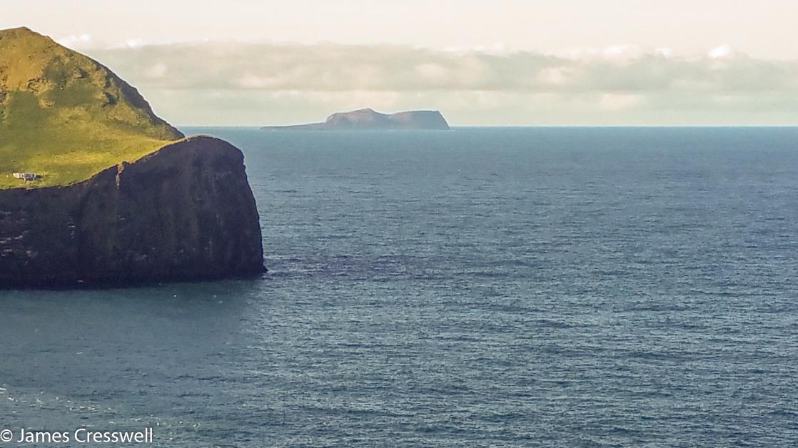 A photograph of a distant island, Surtsey, taken on the GeoWorld Travel Iceland volcano trip and geology holiday