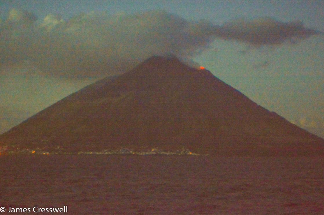 A nighttime photograph of Stromboli volcano with a small eruption, taken on a GeoWorld Travel volcano trip and geology tour