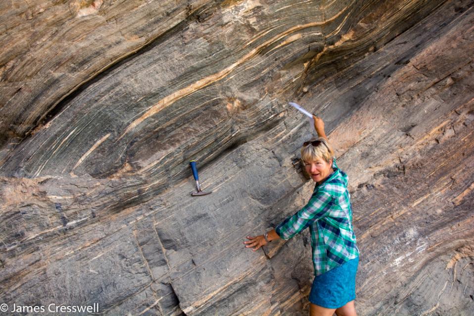 A photograph of Nicole Grunert pointing out boudins in amphibolite, taken on a GeoWorld Travel Namibia geology trip, tour and holiday