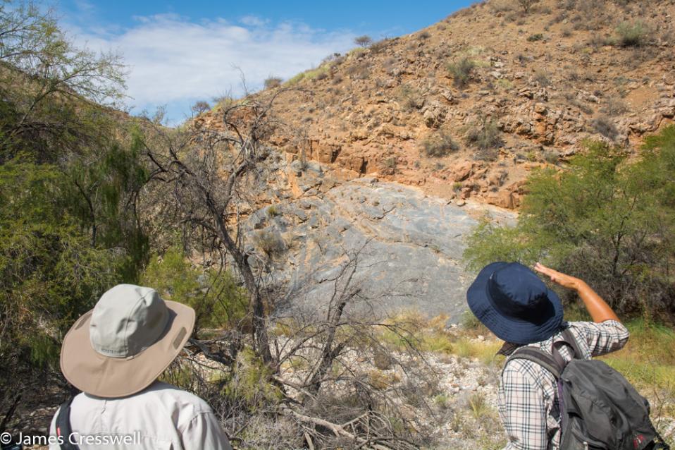 A photograph two people in the foreground with the Naukluft thrust fault and Sole dolomite behind in the Namib-Naukluft National Park, taken on a GeoWorld Travel Namibia geology trip, tour and holiday