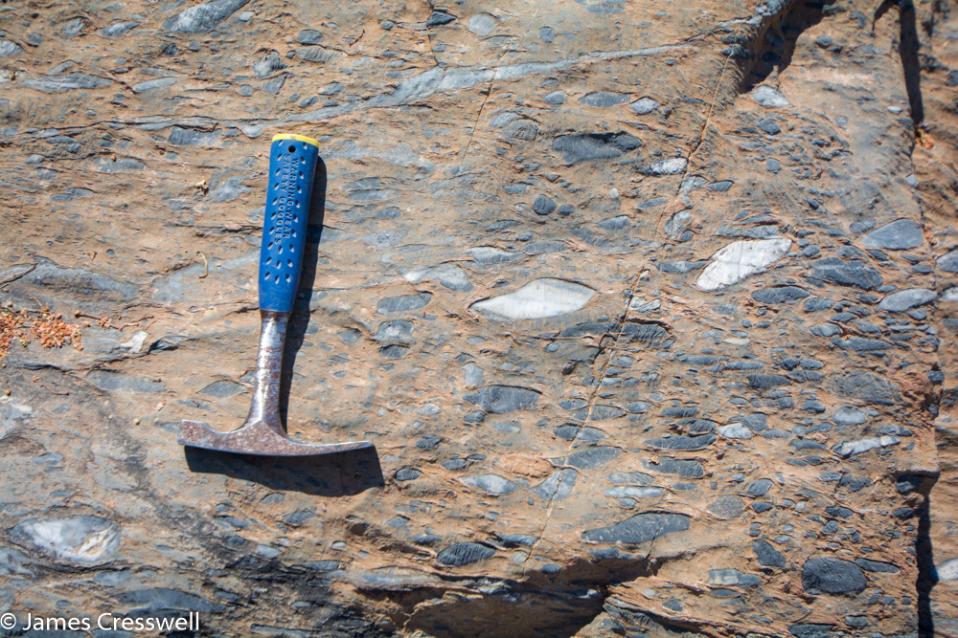 A photograph Drop-stone Snowball Earth deposits with a geological hammer for scale, taken on a GeoWorld Travel Namibia geology trip, tour and holiday