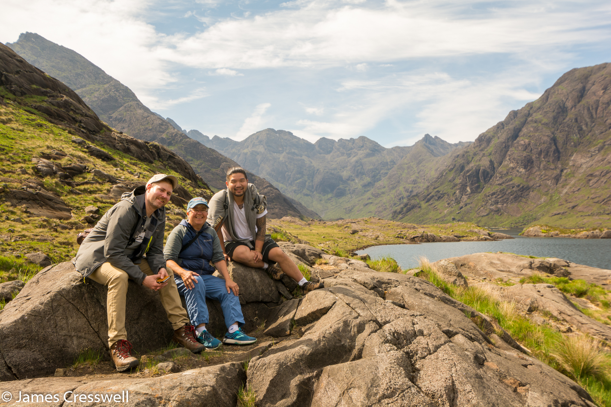 A photograph of three people at Loch Coruisk with the Black Cuillin in the back ground, Isle of Skye, taken on a GeoWorld Travel Scotland geology trip, tour and holiday