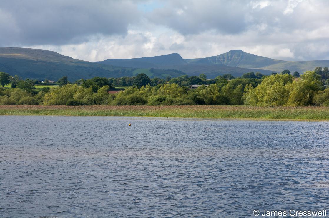 A photograph of Llangorse Lake with the Brecon Beacons behind
